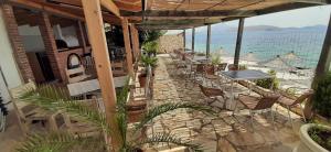un patio con mesas y sillas en la playa en Rock Star-Pllakat en Sarandë