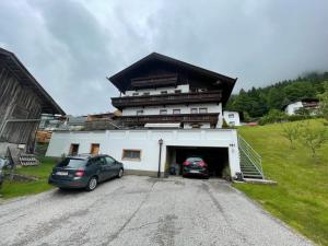 a building with two cars parked in a garage at Appartements Alpenblick in Finkenberg