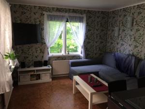 sala de estar con sofá azul y ventana en Inga-Majs stuga en Tvååker