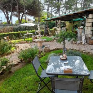 uma mesa e cadeiras num jardim com uma árvore em B&B Romangia em Sorso