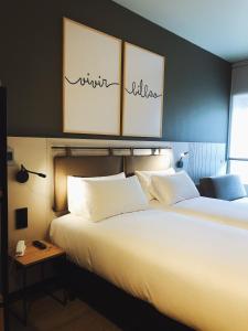 a bedroom with two beds with white pillows at Hotel Bed4U Bilbao in Bilbao