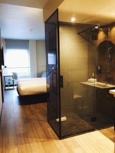 a room with a bed and a glass shower at Hotel Bed4U Bilbao in Bilbao