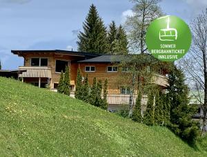 a house on a hill with a sign on it at Ferienwohnung Riezler in Hirschegg