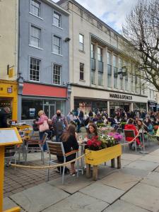 a group of people sitting at tables in an outdoor cafe at Heart of YORK in York