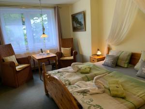 a bedroom with a bed with a stuffed animal on it at Hotel-Pension Teutonia in Braunlage