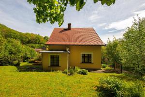 uma pequena casa amarela com um telhado vermelho em Vila Republika em Malá Skála
