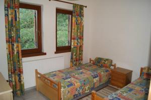 una camera da letto con due letti e due finestre di Spacious Paradise with stone-build patio a Chorefto
