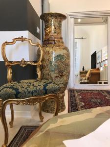 un grande vaso seduto accanto a una sedia in una stanza di Sanctus Syrus 4 ad Albenga