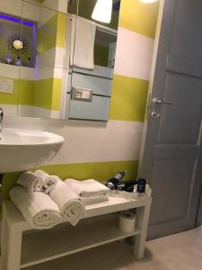 uma casa de banho com um lavatório e uma prateleira com toalhas em Sanctus Syrus 4 em Albenga