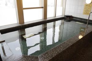 una piscina d'acqua in una stanza con finestre di Hotel Hokke Club Osaka ad Osaka