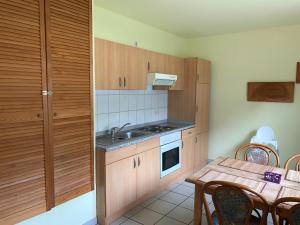a kitchen with wooden cabinets and a table with chairs at Hotel-Pension Teutonia in Braunlage