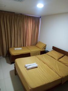 zwei Betten in einem Hotelzimmer mit Handtüchern darauf in der Unterkunft Hostal green bay in San Andrés