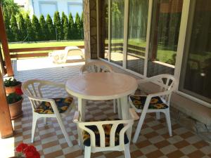 een veranda met een tafel en stoelen op een patio bij Frankie Holiday Apartment I. in Balatongyörök