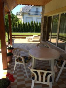 een patio met een tafel en stoelen op een veranda bij Frankie Holiday Apartment I. in Balatongyörök +10 foto's