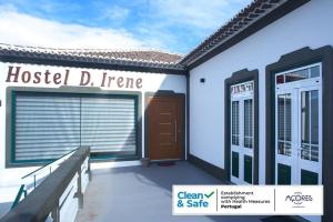 a house with a garage and a sign that reads hostel d fire at D. Irene Hostel in Lajes