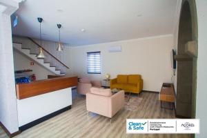 a living room with a couch and a yellow chair at D. Irene Hostel in Lajes