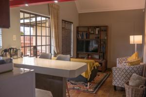 una cucina e un soggiorno con divano e tavolo di Camdeboo Place a Dullstroom