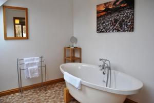 La salle de bains est pourvue d'une baignoire et d'une photo murale. dans l'établissement Orchard House Bed and Breakfast, à Portree 195 autres photos