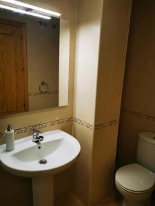 a bathroom with a sink and a toilet and a mirror at Rihuete 2 in Puerto de Mazarrón