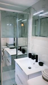 a white bathroom with two sinks and a shower at Maisonnette en hyper centre d’Orléans in Orléans