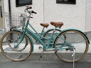 een groene fiets geparkeerd aan de kant van een straat bij Ise Guest House Kazami in Ise