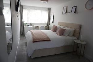 um quarto com uma cama grande e almofadas cor-de-rosa em Amica Guesthouse em Belfast