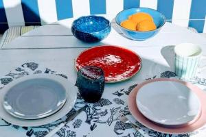 a table with plates and bowls of fruit on it at CASA DA ZECA, GARAGEM GRATUITA, COSTA NOVA in Gafanha da Encarnação