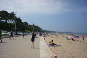 a group of people sitting on the beach at One bedroom holiday apartment Colwyn Bay in Colwyn Bay