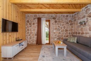ein Wohnzimmer mit einer Steinmauer in der Unterkunft Apart & Spa Beganovic in Dobra Voda
