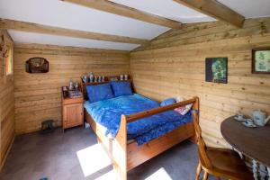 1 dormitorio con 1 cama en una cabaña de madera en Wijndomein de Vier Ambachten -overnachten in de wijngaard, en Simonshaven