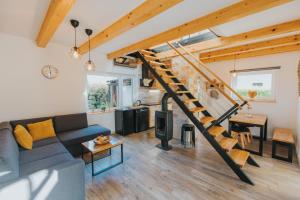 a living room with a couch and a staircase at Vila Kosjenka on lake Sabljaci in Ogulin