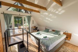 a bedroom with a bed and a balcony at Vila Kosjenka on lake Sabljaci in Ogulin