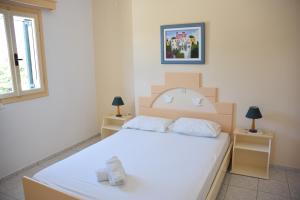 a bedroom with a large white bed with two lamps at Porto Apergis in Agios Ioannis Tinos