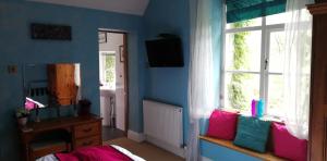 
a living room filled with furniture and a window at Penmachno Hall - self catering suite in Betws-y-coed
