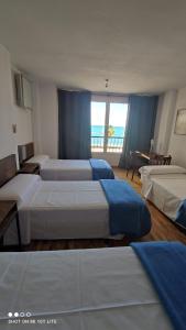 a bedroom with two beds and a view of the ocean at Habitaciones La MAR in Altea