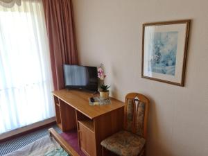 um quarto com uma secretária, uma televisão e uma cadeira em Hotel Restaurant Am Worns Berg em Broock