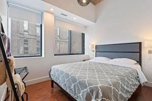 une chambre avec un grand lit et deux fenêtres dans l'établissement mtlFlats - Condotel Le Luxe, à Montréal
