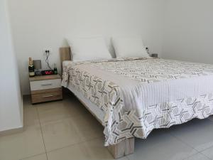 ein Schlafzimmer mit einem großen Bett und einem Nachttisch in der Unterkunft Appartamento Artur in Matulji