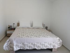 ein Schlafzimmer mit einem Bett mit einer weißen Tagesdecke in der Unterkunft Appartamento Artur in Matulji