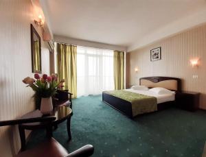 a hotel room with a bedroom with a bed and a couch at Hotel Smarald in Eforie Nord +38 photos