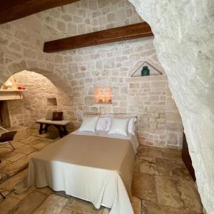 a bedroom with a bed in a stone wall at Trullo Matilde in Martina Franca +44 photos