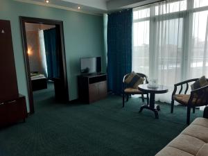a living room with a couch and a tv and a table at Hotel Smarald in Eforie Nord