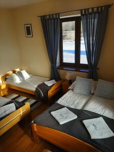 - une chambre avec 3 lits et une fenêtre dans l'établissement WILLA TOMIDA, à Jurgów