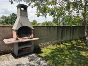 an outdoor oven sitting next to a wall at Countryside Apartment Nika in Čabrunići