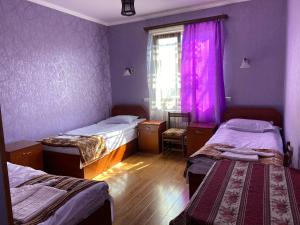 una camera con due letti e una finestra con pareti viola di Aghasu Tun B&B a Odzun
