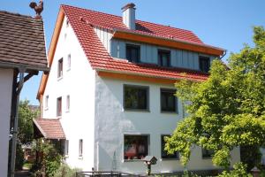 ein weißes Haus mit rotem Dach in der Unterkunft Gästehaus Wacker in Ringsheim