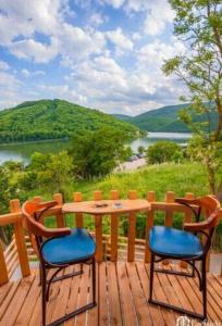 uma mesa e duas cadeiras num deque com vista em Villat Parku i Liqenit em Orllan