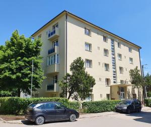 two cars parked in front of a building at Apartament Central Miguel in Turda