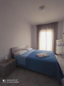 a bedroom with a blue bed and a window at APPARTAMENTO SANTUCCI in Rodi Garganico