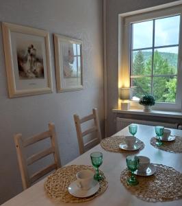 a dining room table with two chairs and a window at Apartament 39 in Karpacz